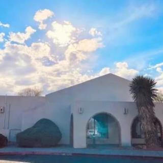 A white building under a vibrant sky with clouds and sunlight.