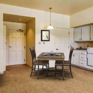 A cozy kitchen and dining area with a wooden table, chairs, and modern appliances.