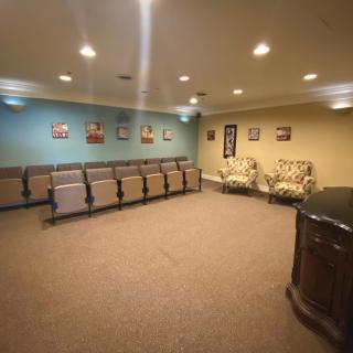 A well-lit waiting room with rows of chairs and wall decorations.
