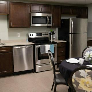 A modern kitchen with stainless steel appliances and a cozy dining area.