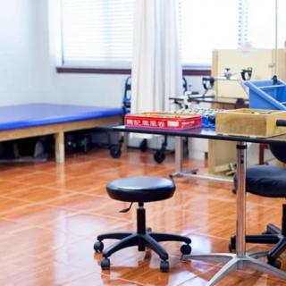 A rehabilitation room equipped with a therapy bed and medical equipment.