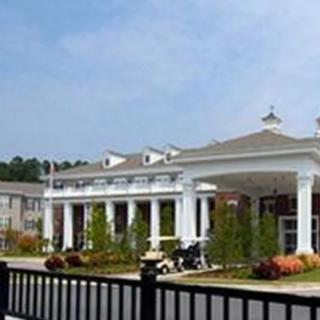 A building with a grand entrance featuring columns and a landscaped foreground.