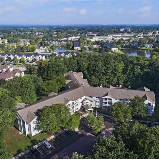 Aerial view of a suburban building surrounded by trees and greenery.