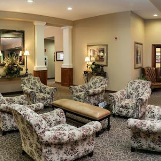 A cozy seating area in a lobby featuring floral patterned chairs and warm lighting.