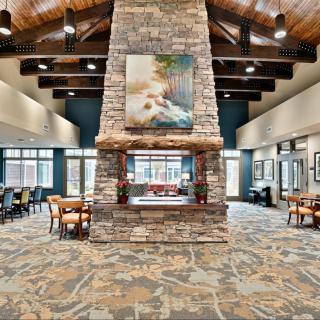 A modern lobby with a central stone fireplace and comfortable seating areas.