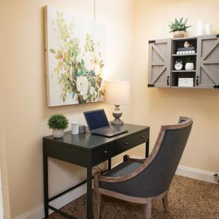 A cozy home office corner with a sleek desk, comfortable chair, and decorative elements.