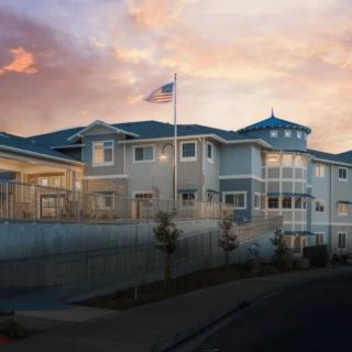 A beautiful residential building at sunset with a flag flying in front.