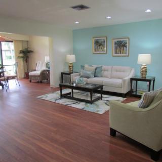 A cozy living room with modern furniture and a light blue accent wall.