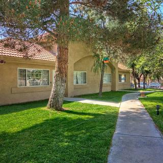 A residential building with a well-maintained lawn and surrounding trees.