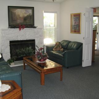 A cozy living room with a fireplace, sofas, and a wooden coffee table.