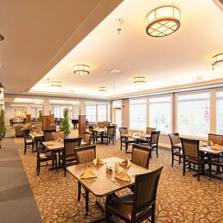 A well-lit dining area with neatly arranged tables and chairs.