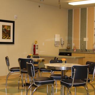 A modern dining area with tables and chairs in a cafe setting.