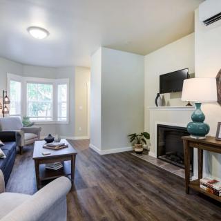 A cozy living room with modern decor, featuring a fireplace and hardwood flooring.