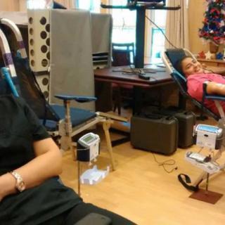 Two people relaxing in a room with medical equipment and chairs.
