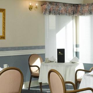 A cozy restaurant interior with elegant seating and sunlight streaming through the window.