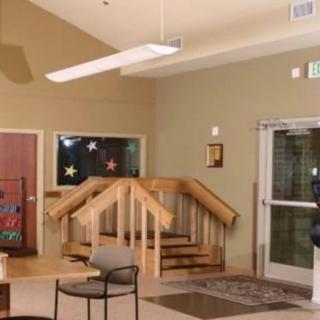 A lobby area with a small staircase, chairs, and an entrance door.
