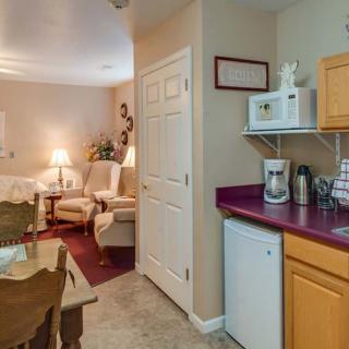 A cozy kitchenette and living room area with compact appliances and comfortable seating.