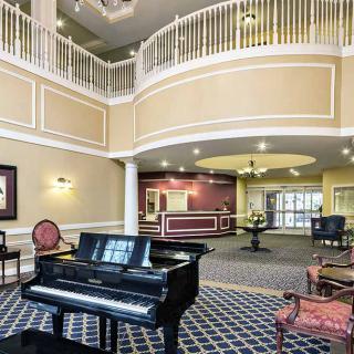 Elegant lobby with a grand piano and a two-story open space.