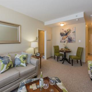 A cozy living room with a sofa, chairs, and decorative elements such as pillows and artwork.