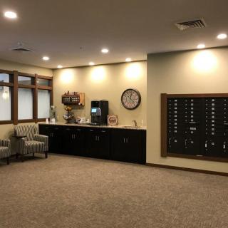 A cozy waiting area with seating, a coffee station, and soft lighting.