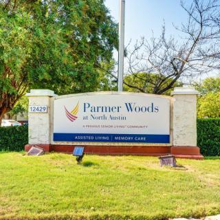 Entrance sign for Parmer Woods at North Austin surrounded by greenery.