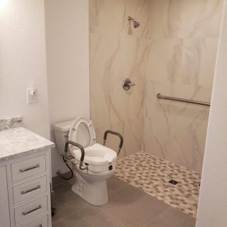 Modern accessible bathroom with a shower and handrails.