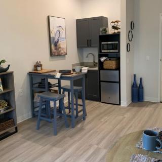A modern kitchen with a small dining area, featuring stylish furniture and appliances.