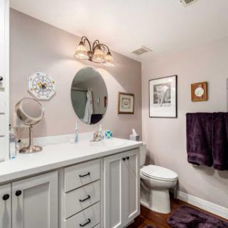 A well-decorated bathroom featuring a stylish vanity, round mirror, and elegant lighting.