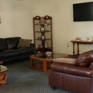 A cozy living room with sofas, a coffee table, and a mounted TV.