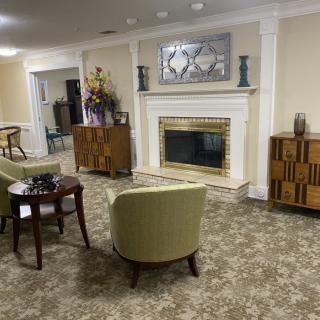 A cozy living room featuring a fireplace, armchairs, and stylish furniture.