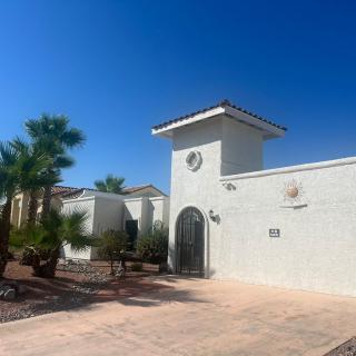 A sunny day at a modern residence surrounded by palm trees and desert landscaping.