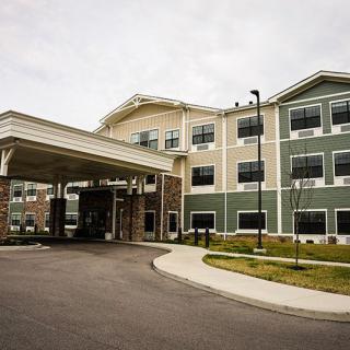 A modern residential building with a covered entrance and driveway.