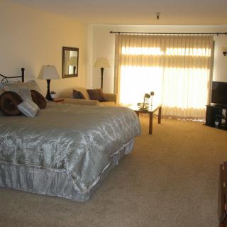 A spacious bedroom with a large bed, TV, and cozy furnishings.