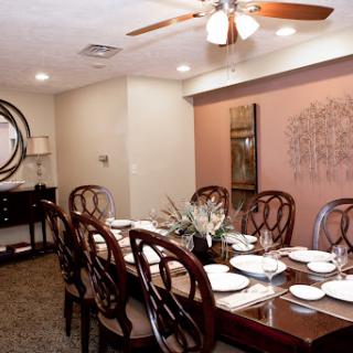 A beautifully arranged dining room featuring a long wooden table set with dishes and elegant decor.