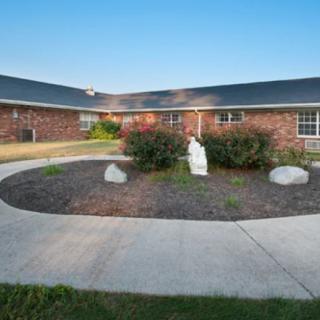 A brick building with a courtyard featuring a statue and landscaped pathway.