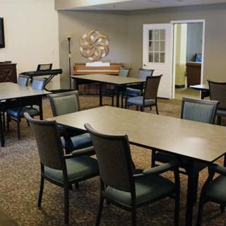 A conference or meeting room with multiple tables and chairs arranged for group discussions.