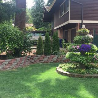 A beautifully landscaped garden with vibrant flowers and lush greenery in front of a house.