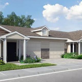 A suburban house with a garage and driveway, surrounded by greenery under a blue sky.