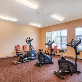 A small fitness room with various cardio exercise machines.