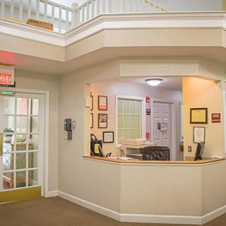 A reception area with a desk and adjacent office space.