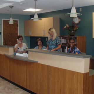 A reception area in an office with employees behind the counter.