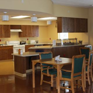 A spacious kitchen and dining area featuring modern appliances and wooden furniture.