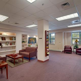 A cozy library with comfortable seating and bookshelves filled with books.