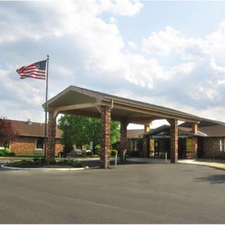 A welcoming entrance to a community facility, complete with an American flag and landscaped surroundings.
