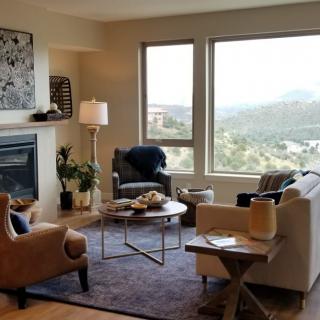 A cozy living room with modern furnishings and a stunning mountain view through large windows.