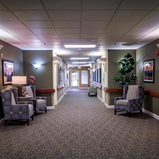 A well-lit hallway with chairs and decorative elements.
