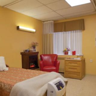 A cozy, well-furnished bedroom with a red chair and warm lighting.