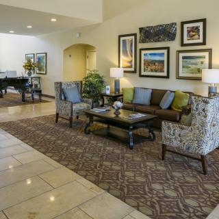 A well-decorated hotel lobby with comfortable seating and framed artwork on the wall.