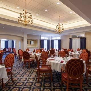 An elegantly decorated dining room with chandeliers, set up for a banquet.