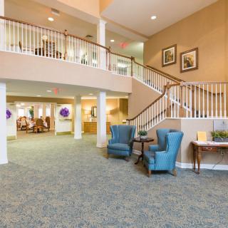 A bright and welcoming lobby with comfortable seating and a staircase.